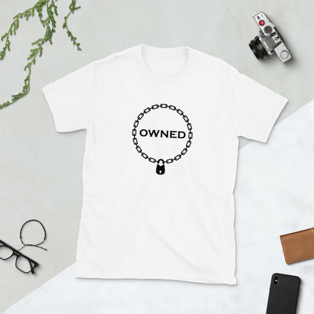 White t-shirt with an image of a BDSM chain collar with a lock and the word Owned printed in the center of the collar. The design is printed on the front of the shirt.