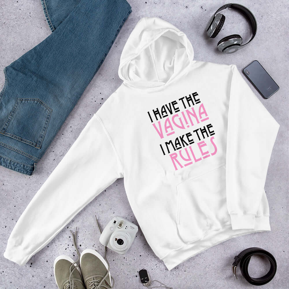 White Black hoodie sweatshirt with the words I have the vagina , I make the rules printed on the front. The words vagina and rules are pink, the rest of the words are black.