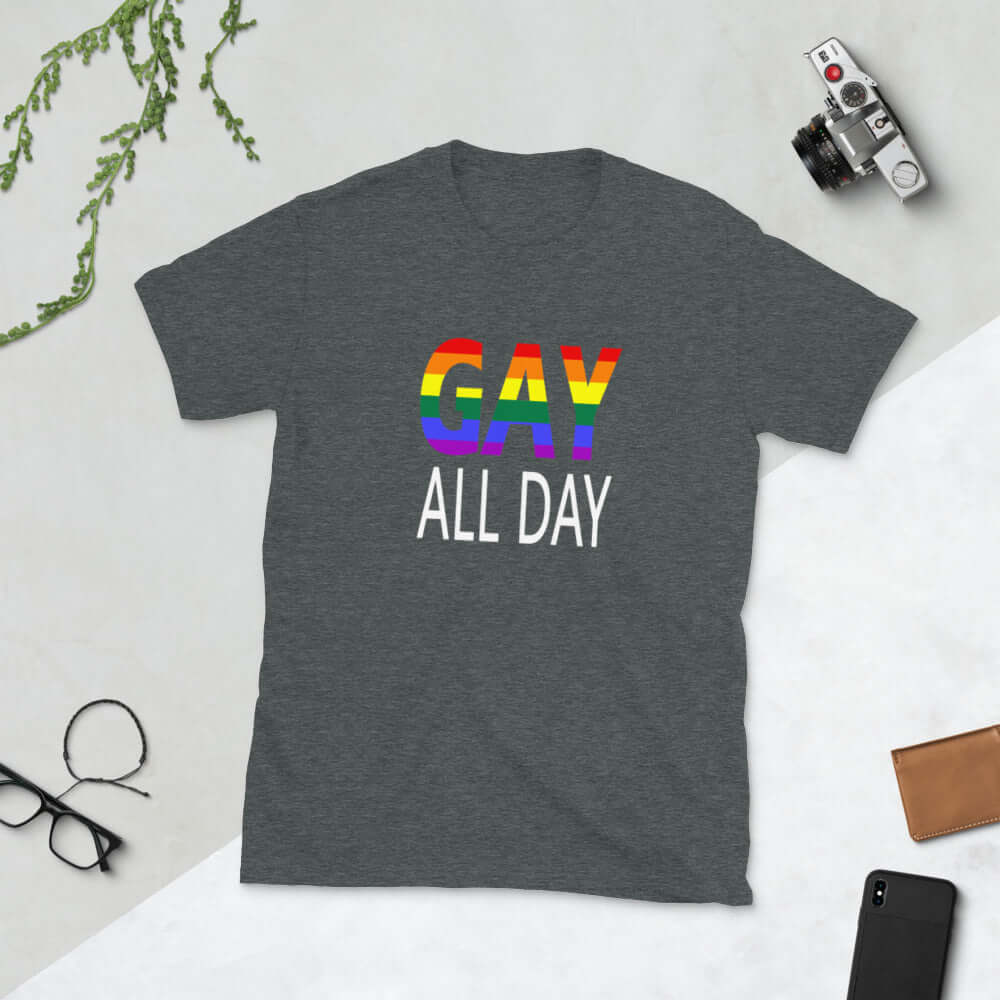 Dark heather grey t-shirt with the words Gay all day printed on the front. The word Gay is in rainbow stripe font. 