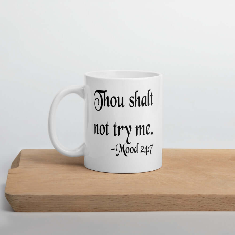 White ceramic coffee mug with the mock scripture quote Thou shalt not try me Mood 24:7 printed on both sides of the mug.