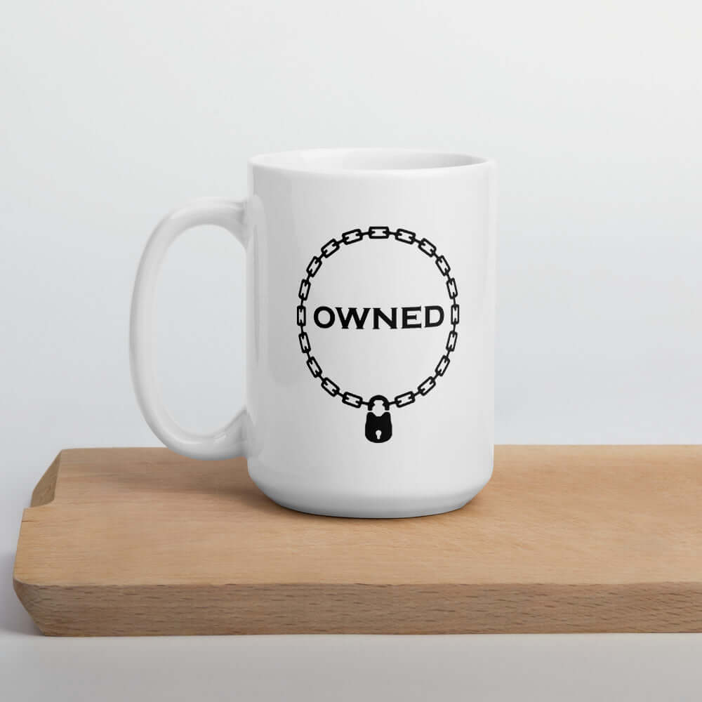 White ceramic coffee mug with an image of a BDSM chain collar with a lock and the word Owned printed in the center of the collar. The design is printed on both sides of the mug.