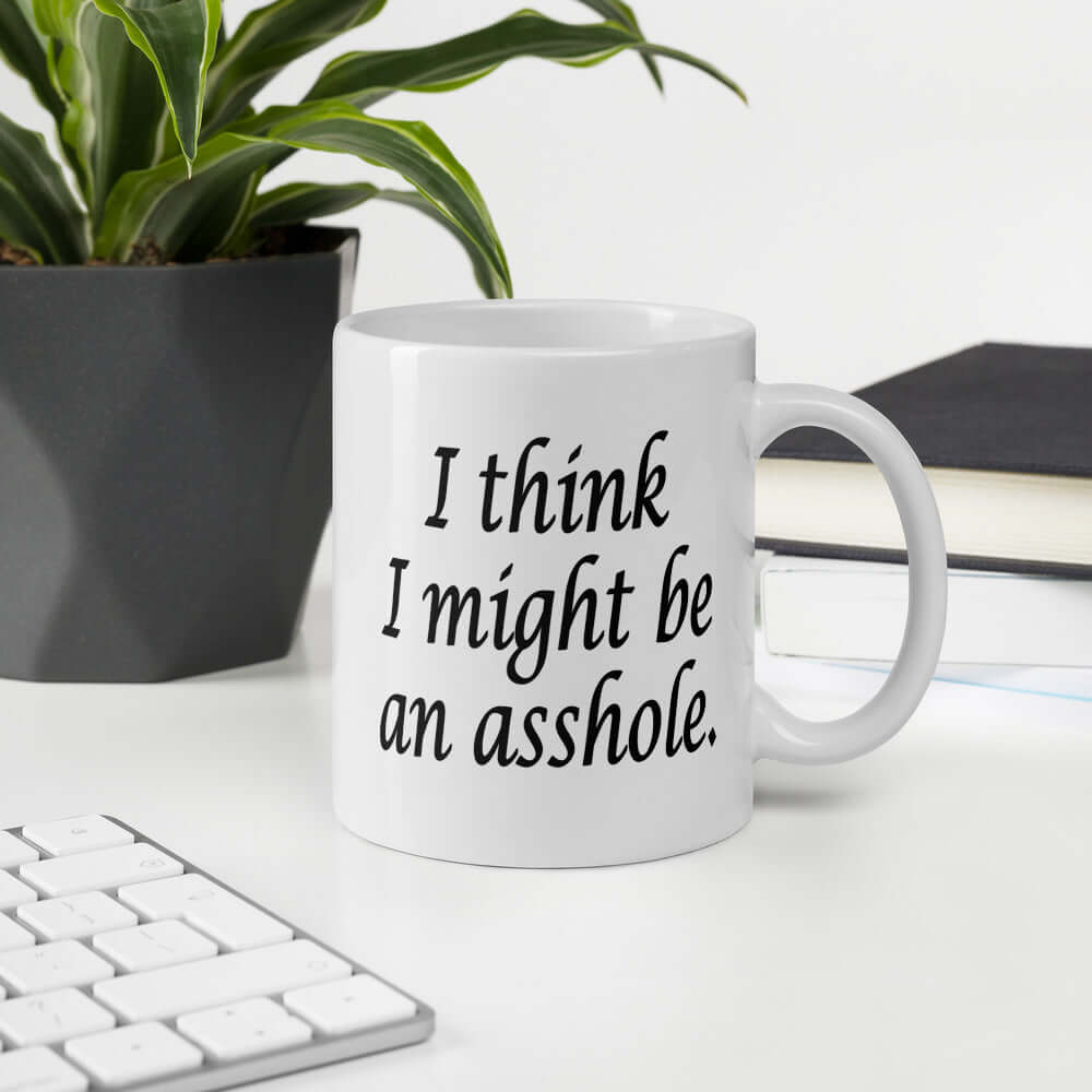 White ceramic coffee mug with the phrase I think I might be an asshole printed on both sides of the mug.