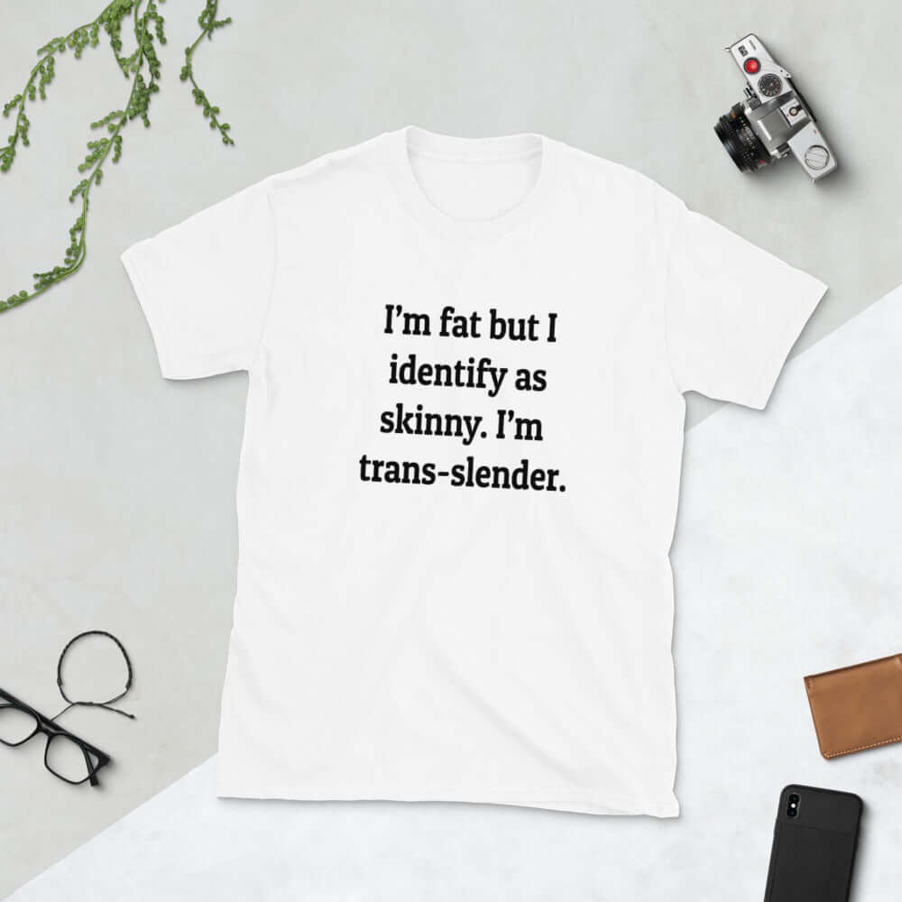White t-shirt with the phrase I'm fat but I identify as skinny. I'm trans-slender printed on the front.