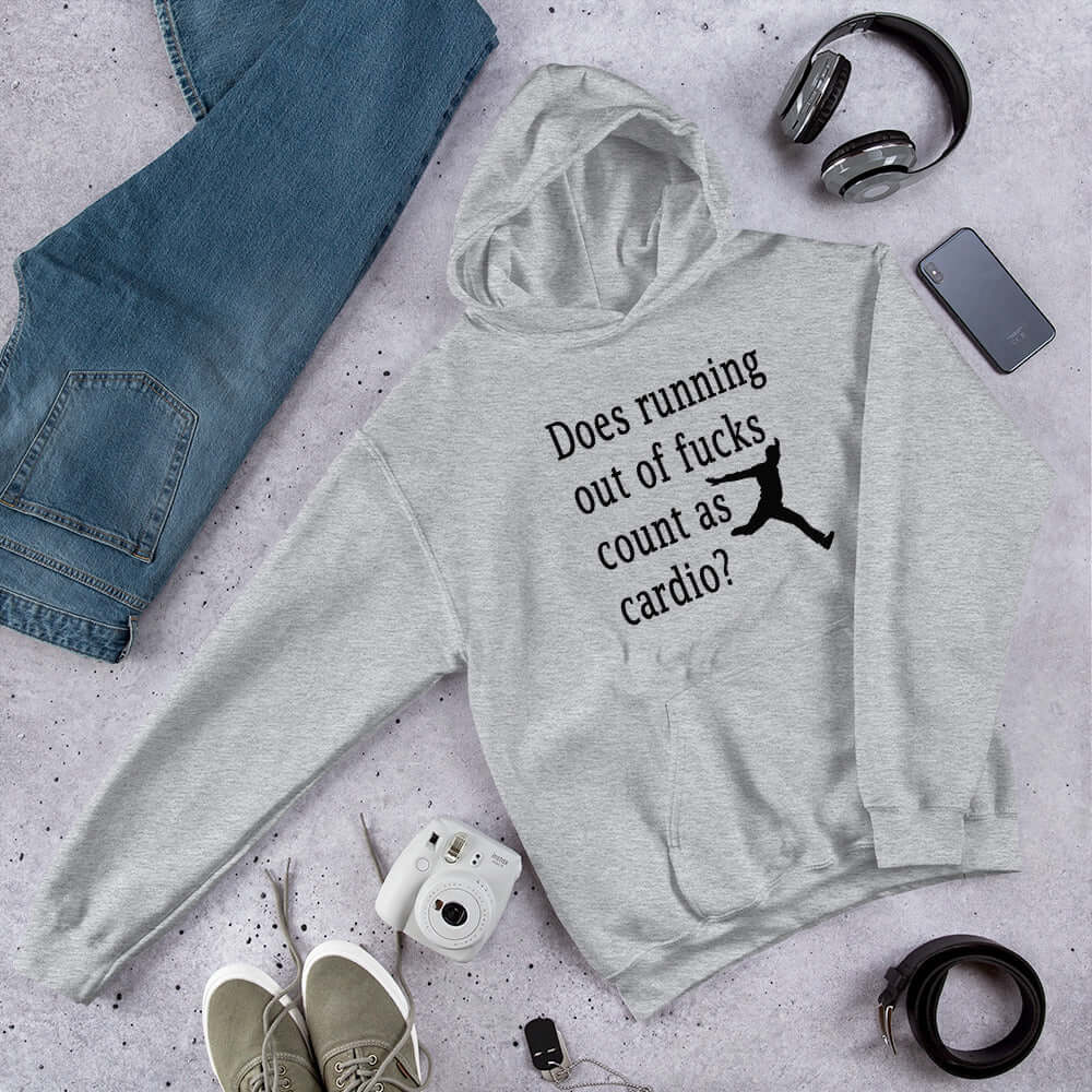 Light grey hoodie sweatshirt with a silhouette image of a running person with the phrase Does running out of fucks count as cardio question mark printed on the front.