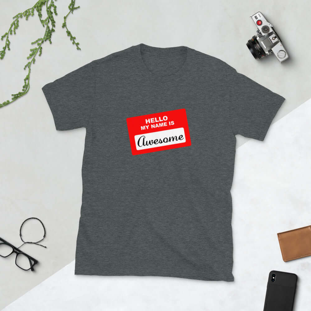 Dark heather grey t-shirt with an image of a classic red and white sticker name tag that says Hello my name is Awesome printed on the front.