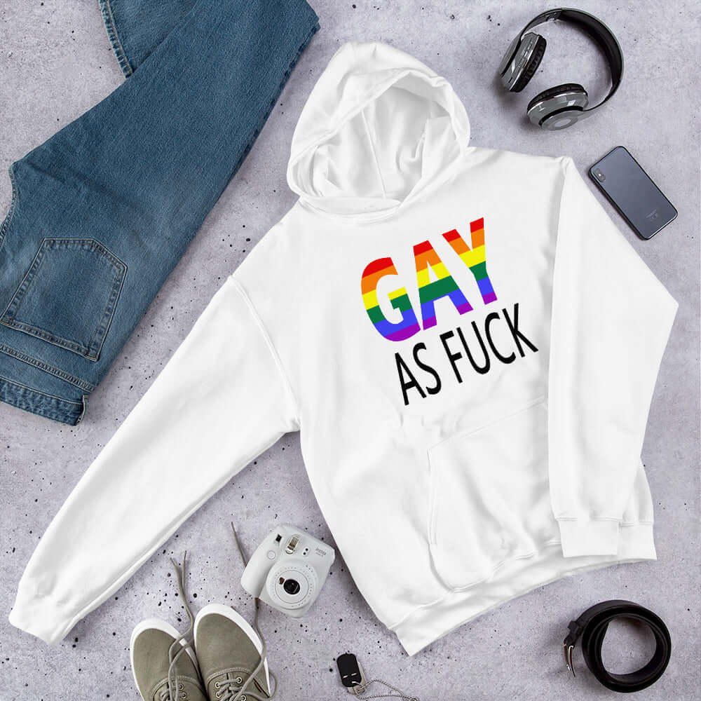 White hoodie sweatshirt with the words Gay as fuck printed on the front. The word Gay is in rainbow stripe font.
