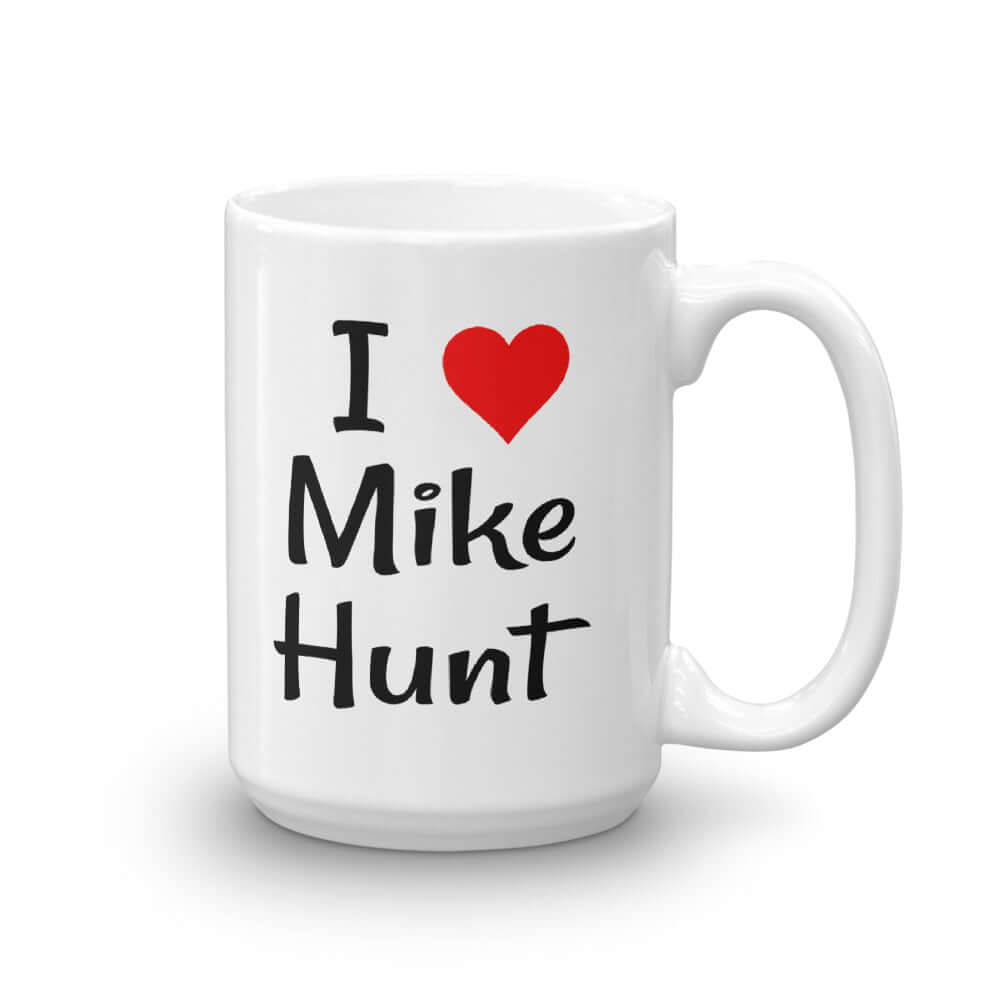 White ceramic coffee mug with pun I heart Mike Hunt printed on both sides of the mug. The heart is red.