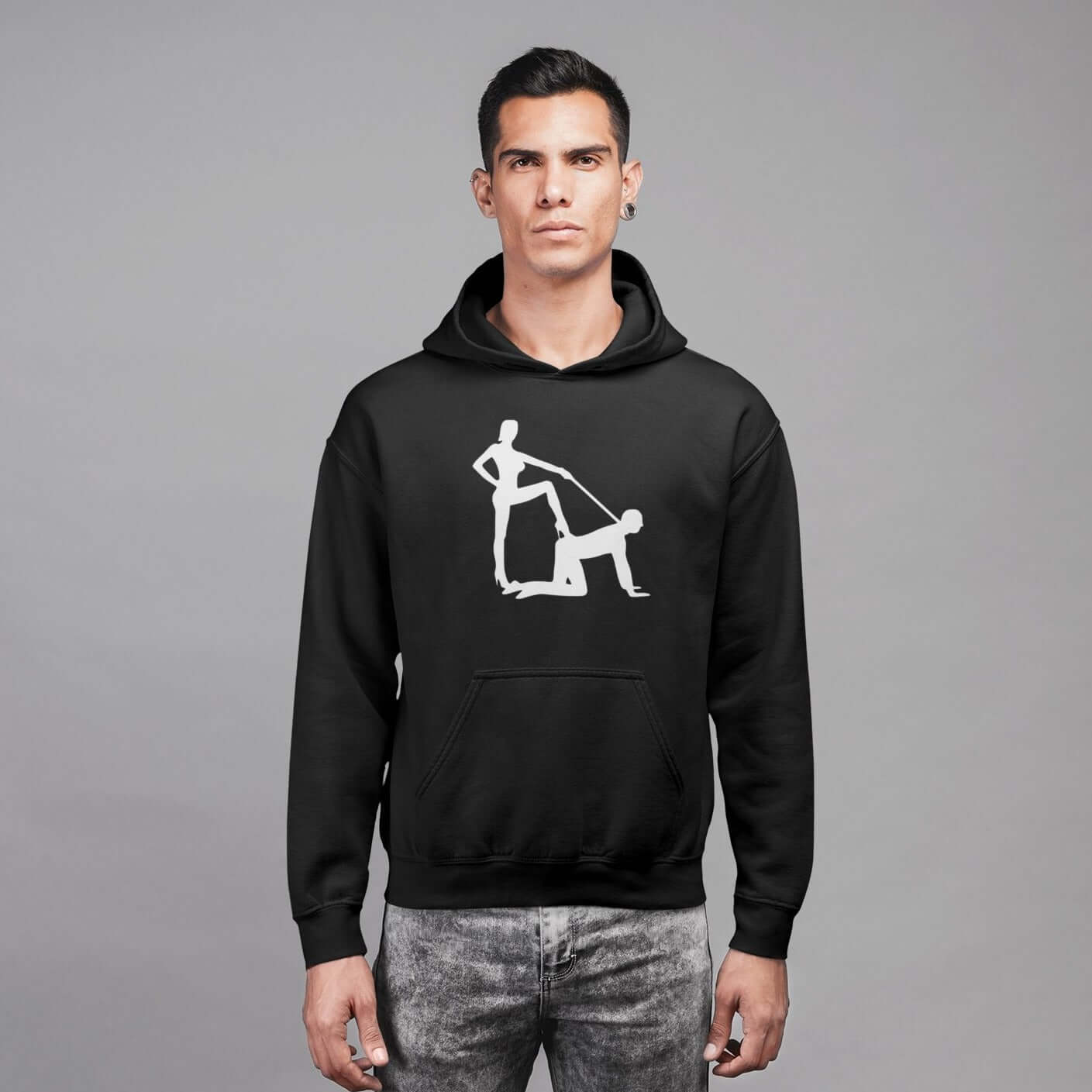 Man wearing a black hooded sweatshirt with silhouette image of a man on his hands and knees and a dominatrix holding his leash printed on the front.