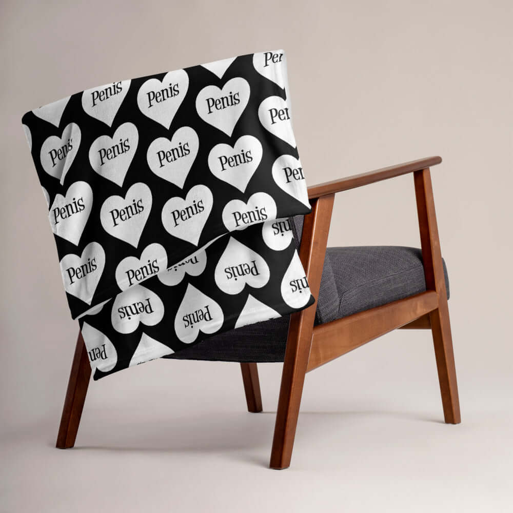 Black throw blanket with a heart image printed all over the blanket. The word penis is inside the heart