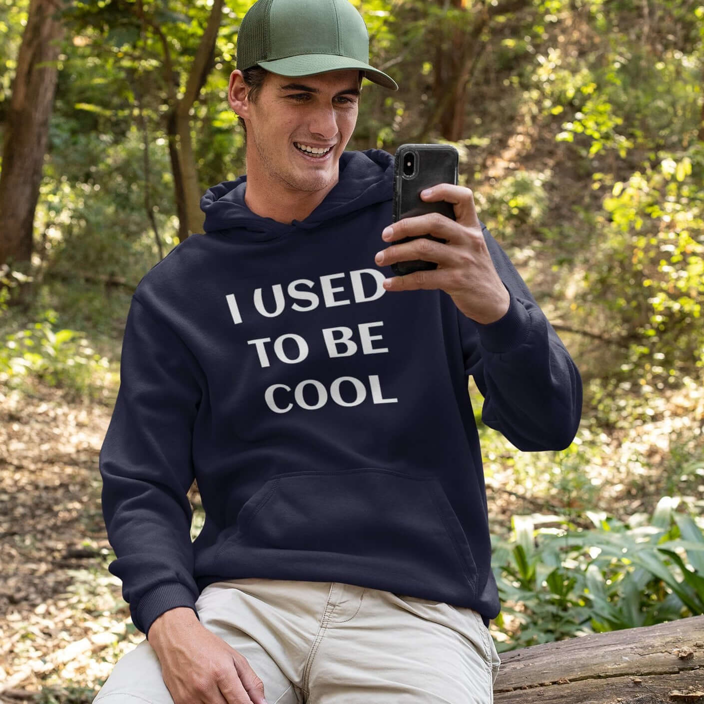 Laughing man wearing a navy blue hoodie sweatshirt with the phrase I used to be cool printed on the front.