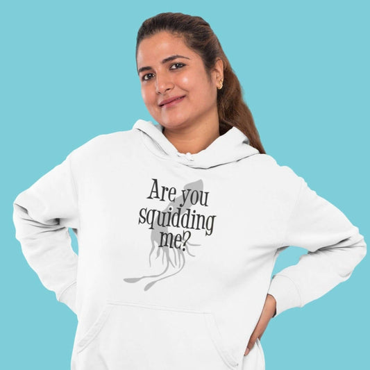 Woman wearing a white hoodie sweatshirt with an image of a squid and the pun phrase Are you squidding me question mark printed on the front.