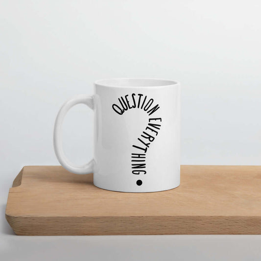 White ceramic coffee mug with the words Question everything printed on both sides. The words are in the shape of a question mark.