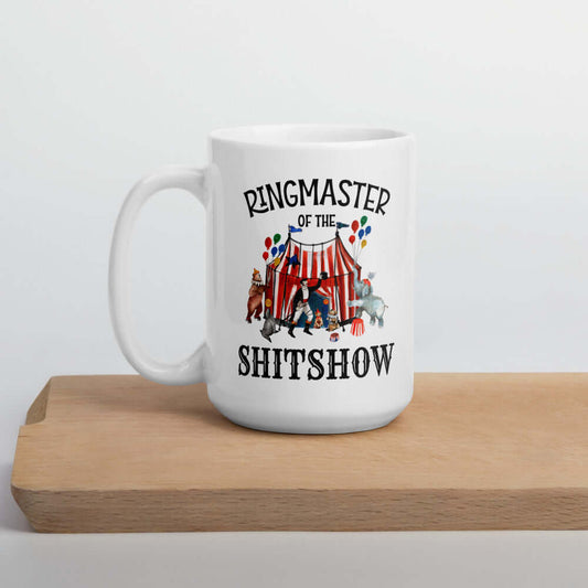 White ceramic coffee mug with a circus theme graphic and the words Ringmaster of the Shitshow printed on both sides.