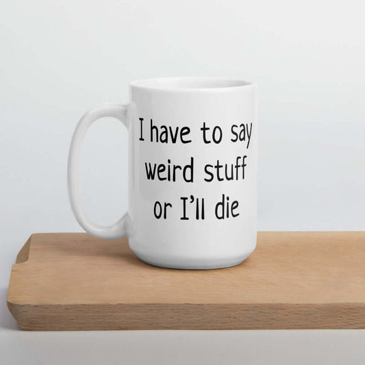 White ceramic coffee mug with the phrase I have to say weird stuff or I'll die printed on both sides.