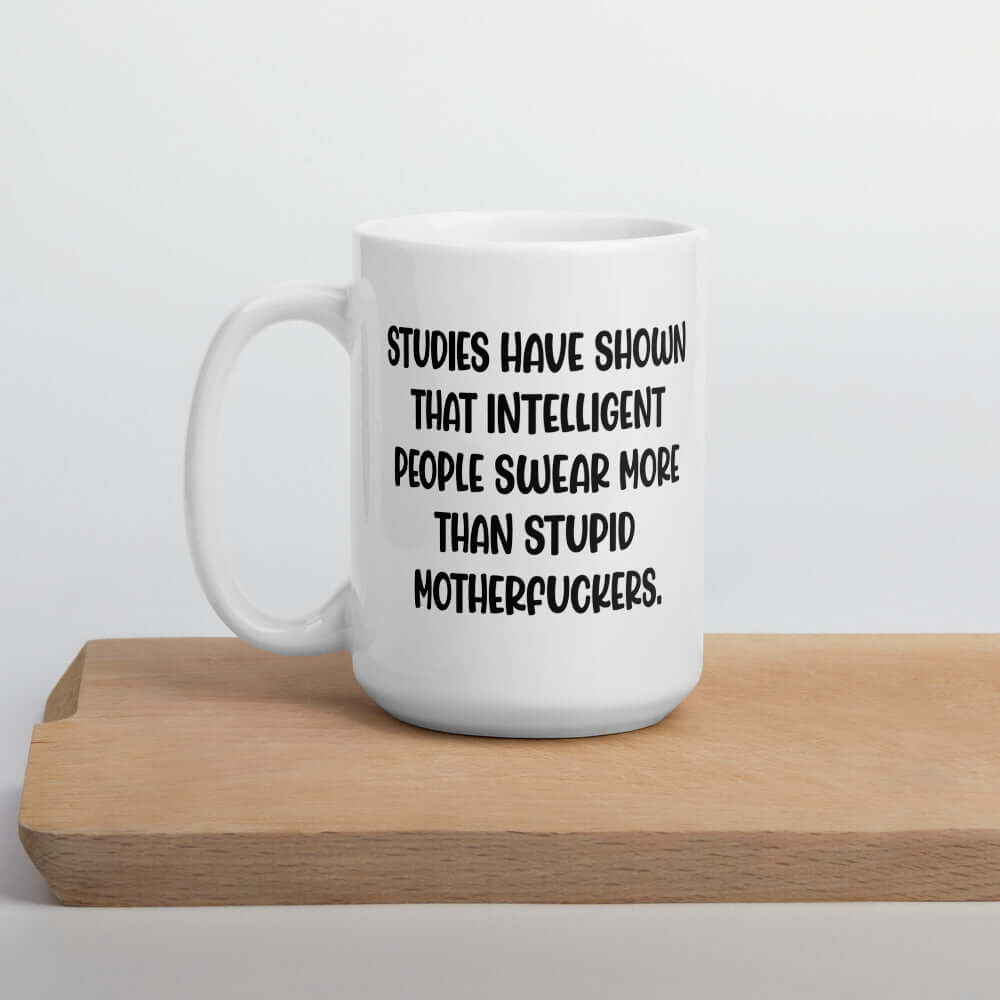 White ceramic coffee mug with the funny phrase Studies have shown that intelligent people swear more than stupid motherfuckers printed on both sides.