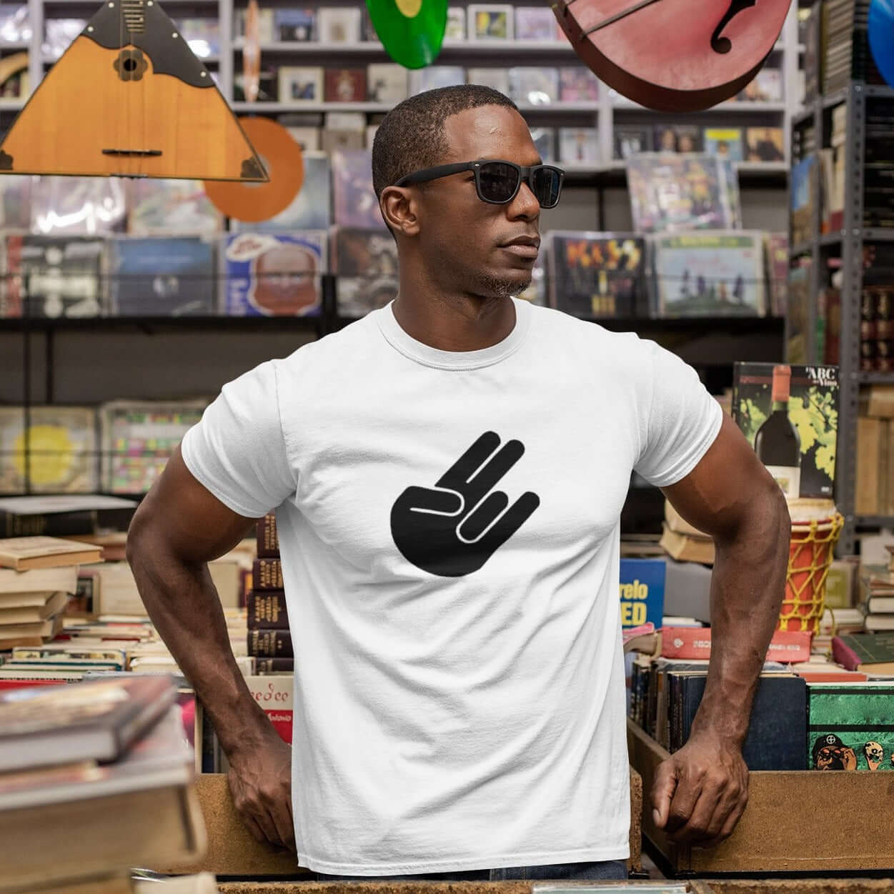 Man wearing a white t-shirt with the universal symbol for The Shocker printed on the front.