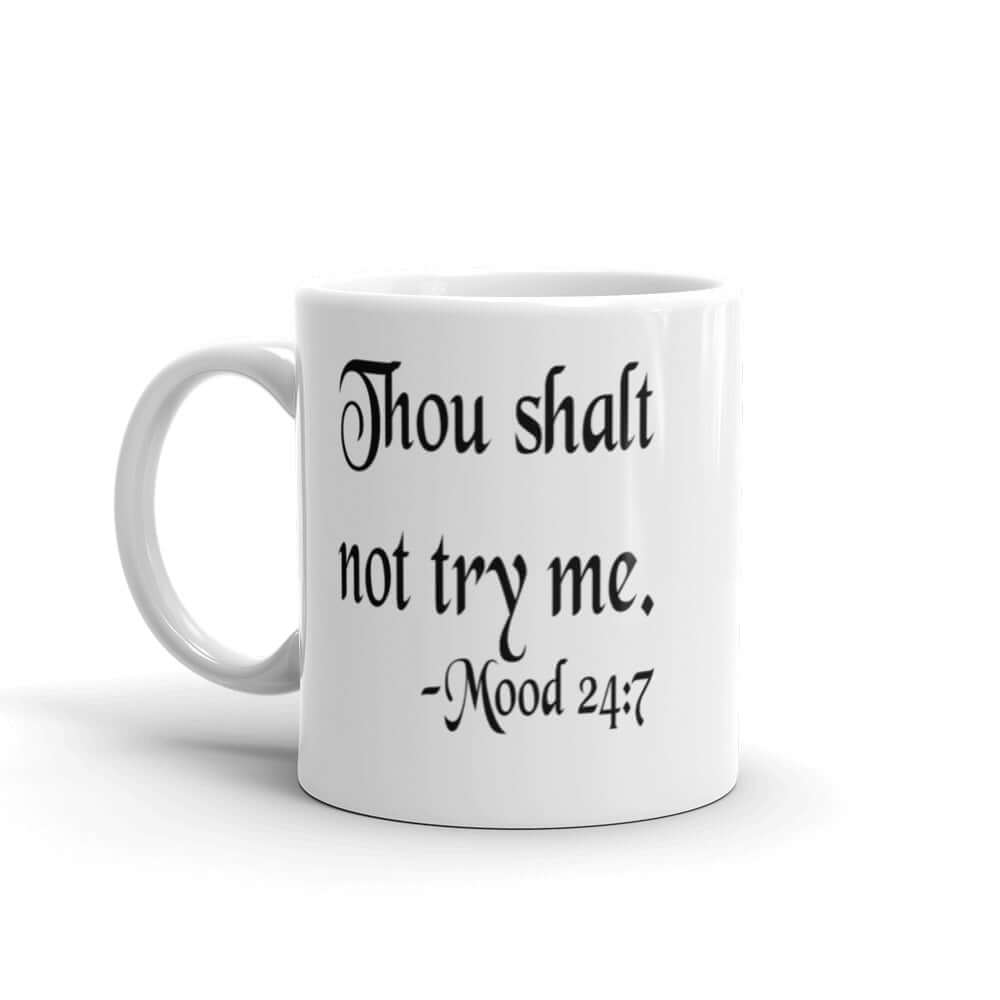 White ceramic coffee mug with the mock scripture quote Thou shalt not try me Mood 24:7 printed on both sides of the mug.