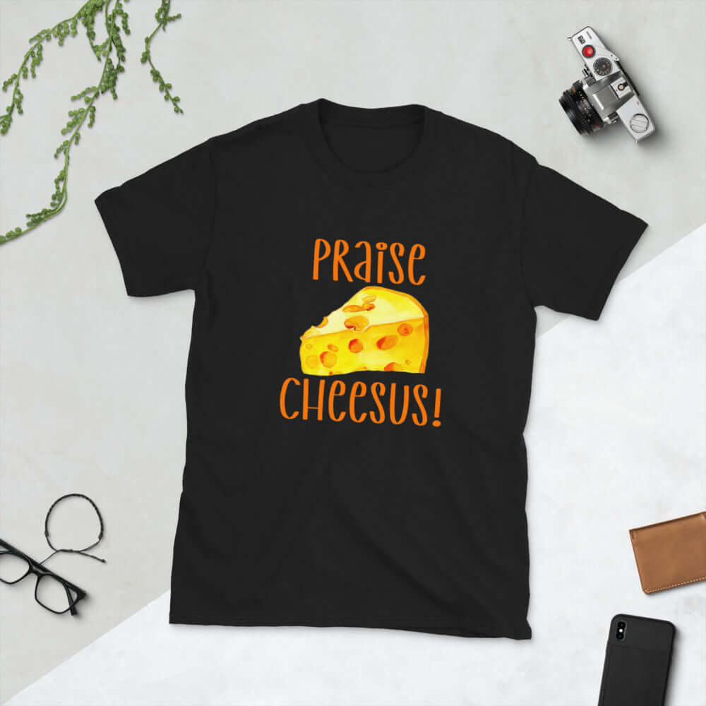 Black t-shirt with funny graphics of a piece of swiss cheese and the words Praise Cheesus printed on the front of the hoodie in yellow and orange.