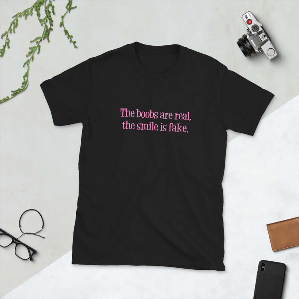 Black t-shirt with the phrase The boobs are real, the smile is fake printed in pink on the front.