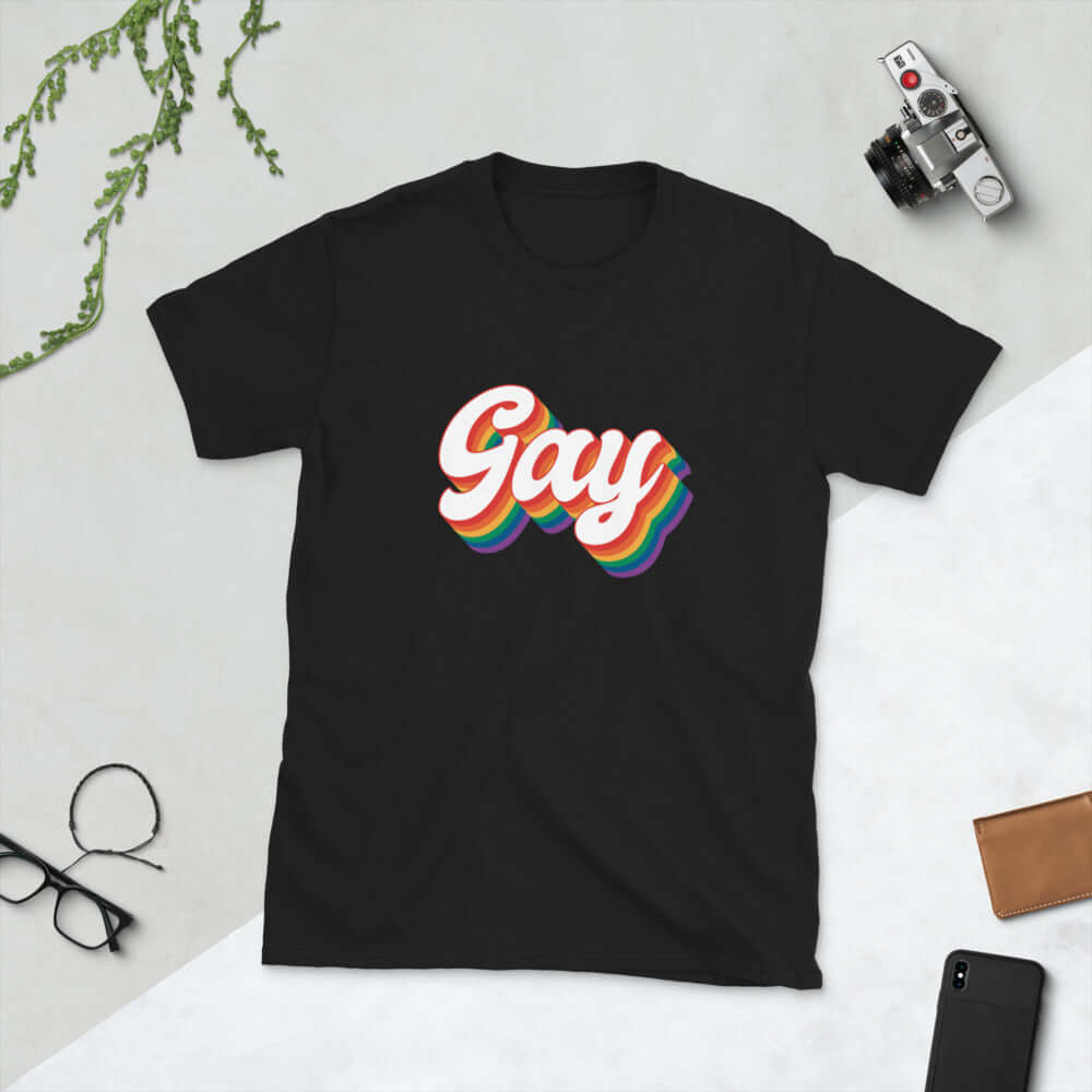 Black t-shirt with the word Gay printed on the front. The word gay is outlined in rainbow.