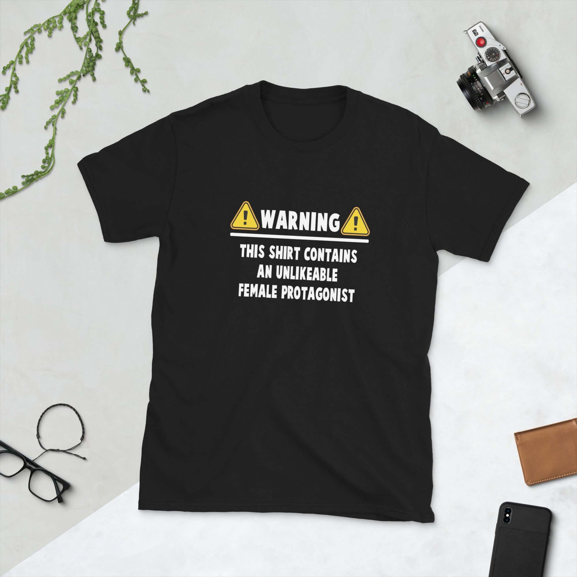 Black t-shirt with the words Warning this shirt contains an unlikable female protagonist printed on the front.