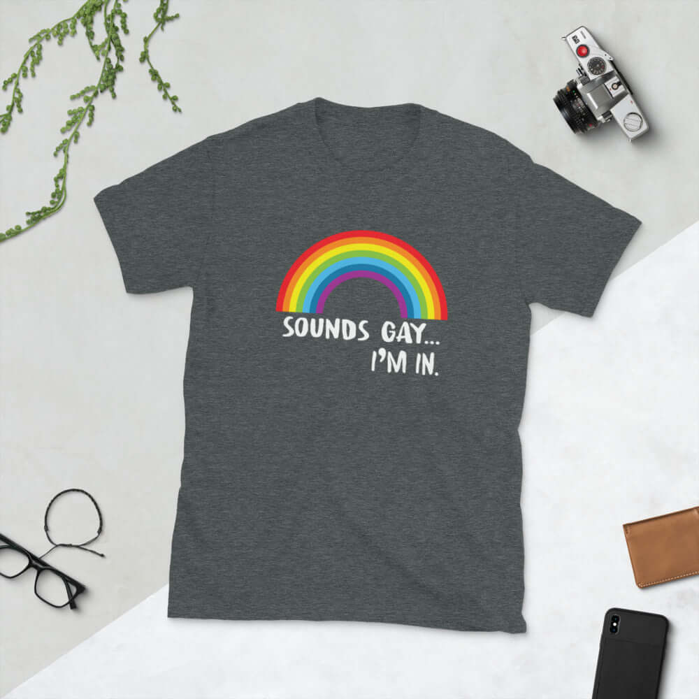 Dark heather grey t-shirt that has an image of a rainbow and the phrase Sounds gay, I'm in printed on the front