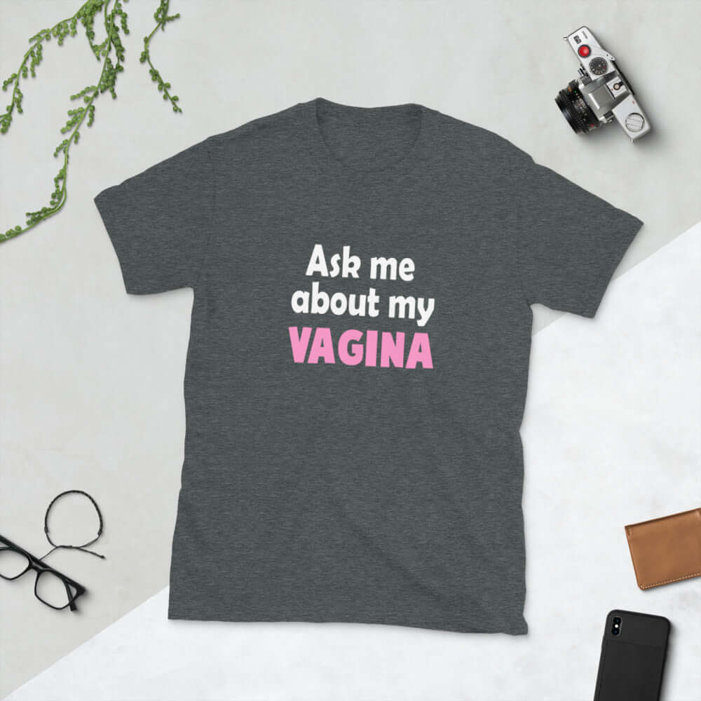 Dark heather grey t-shirt with the words Ask me about my vagina printed on the front. The word vagina is printed in pink. The rest of the text is white..