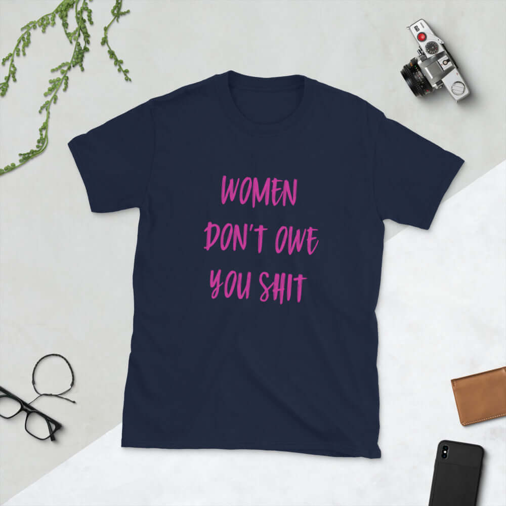 Navy blue t-shirt with the words Women don't owe you shit printed on the front in pink.