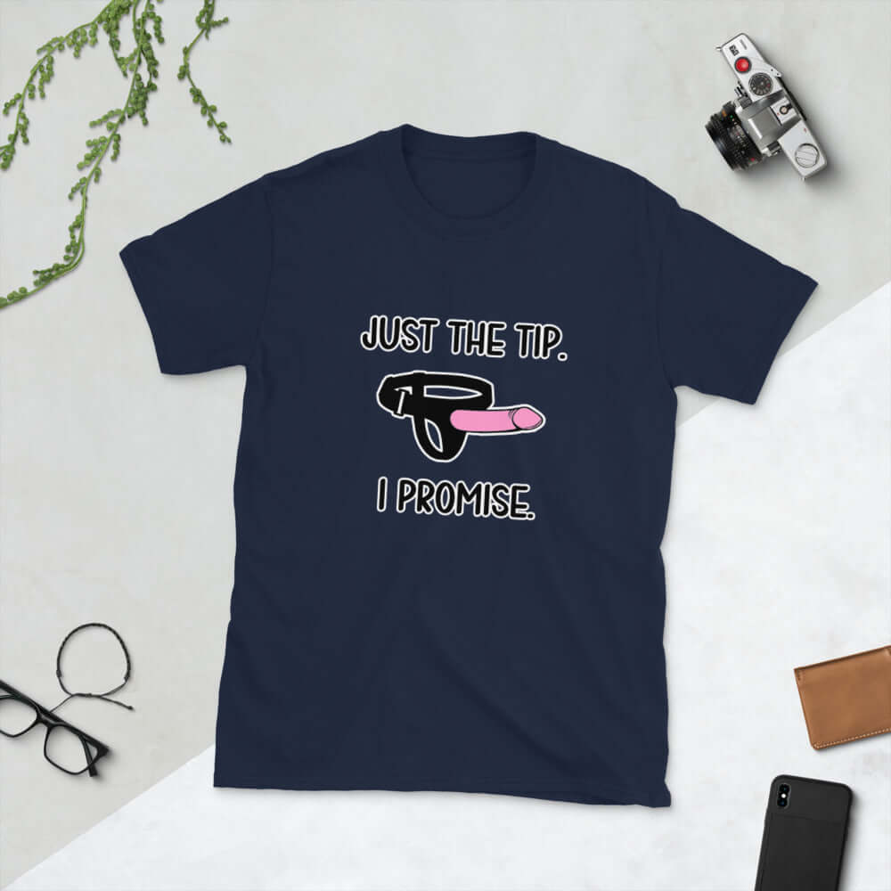 Navy blue t-shirt that has an image of a strap-on dildo and the words Just the tip, I promise printed on the front. The graphics are pink, black and white.