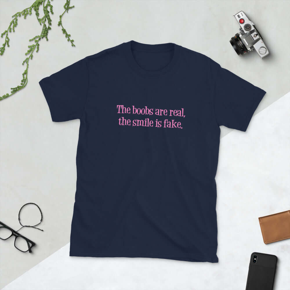Navy blue t-shirt with the phrase The boobs are real, the smile is fake printed in pink on the front.