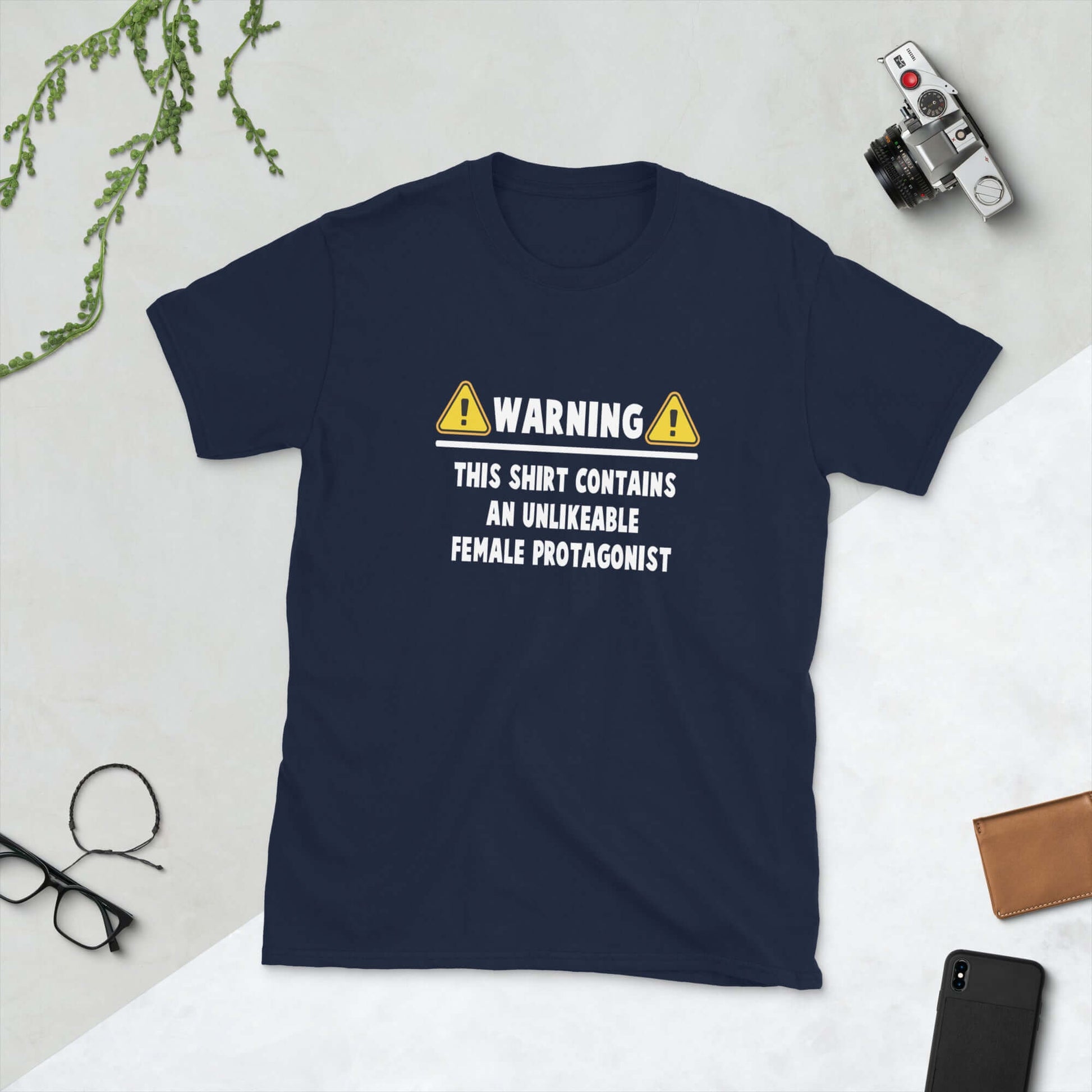 Navy blue t-shirt with the words Warning this shirt contains an unlikable female protagonist printed on the front.