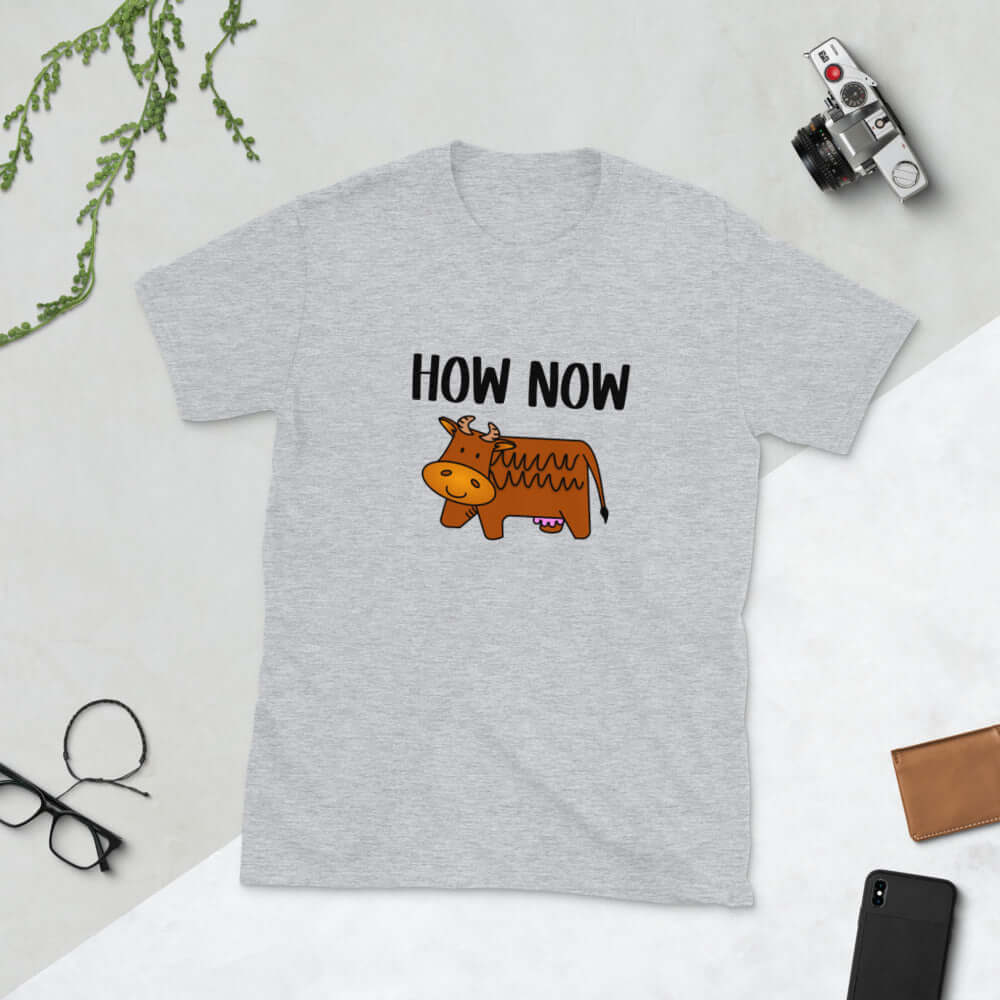 Light grey t-shirt with the words How now and an image of a brown cow printed on the front.