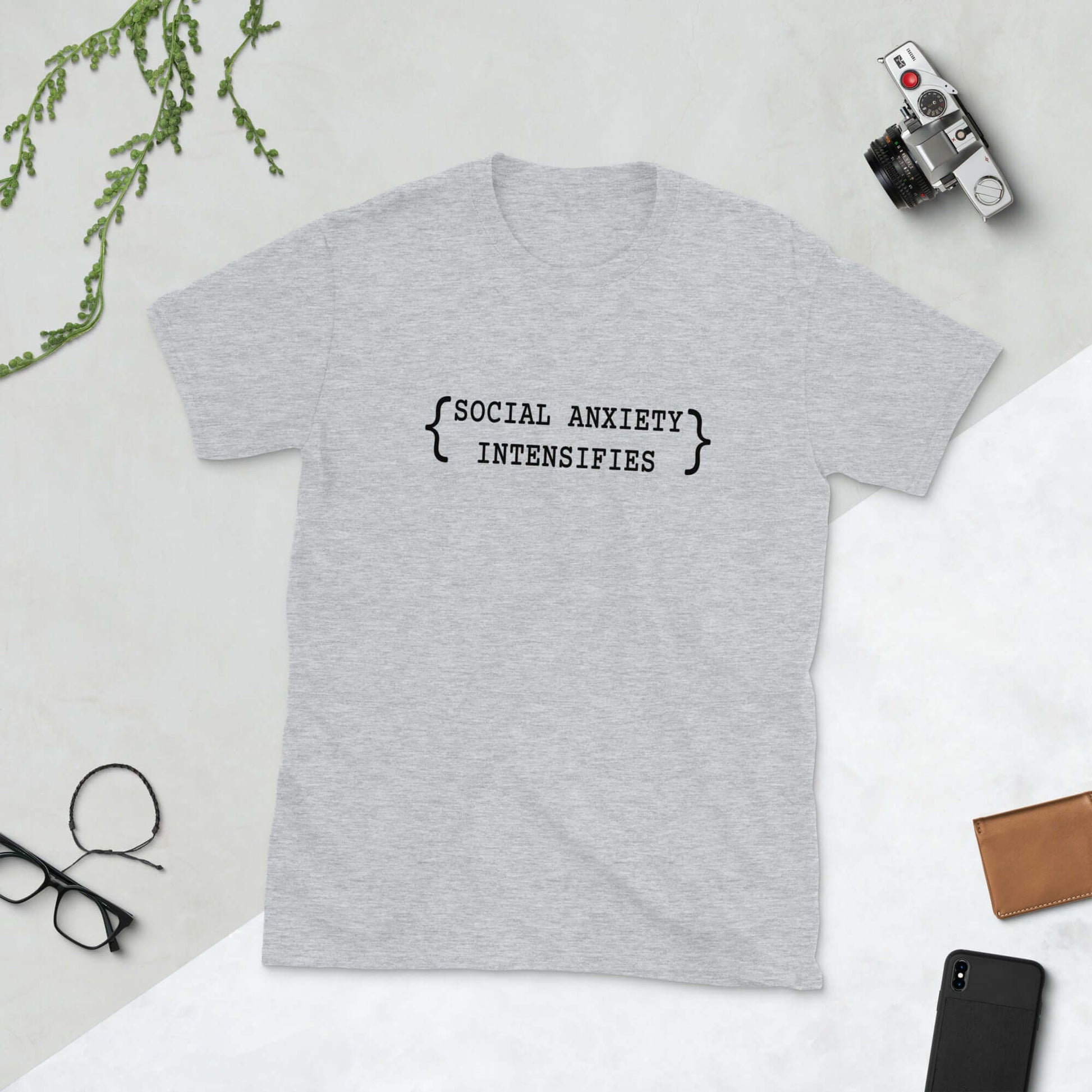 Light grey t-shirt with the words Social anxiety intensifies printed on the front.