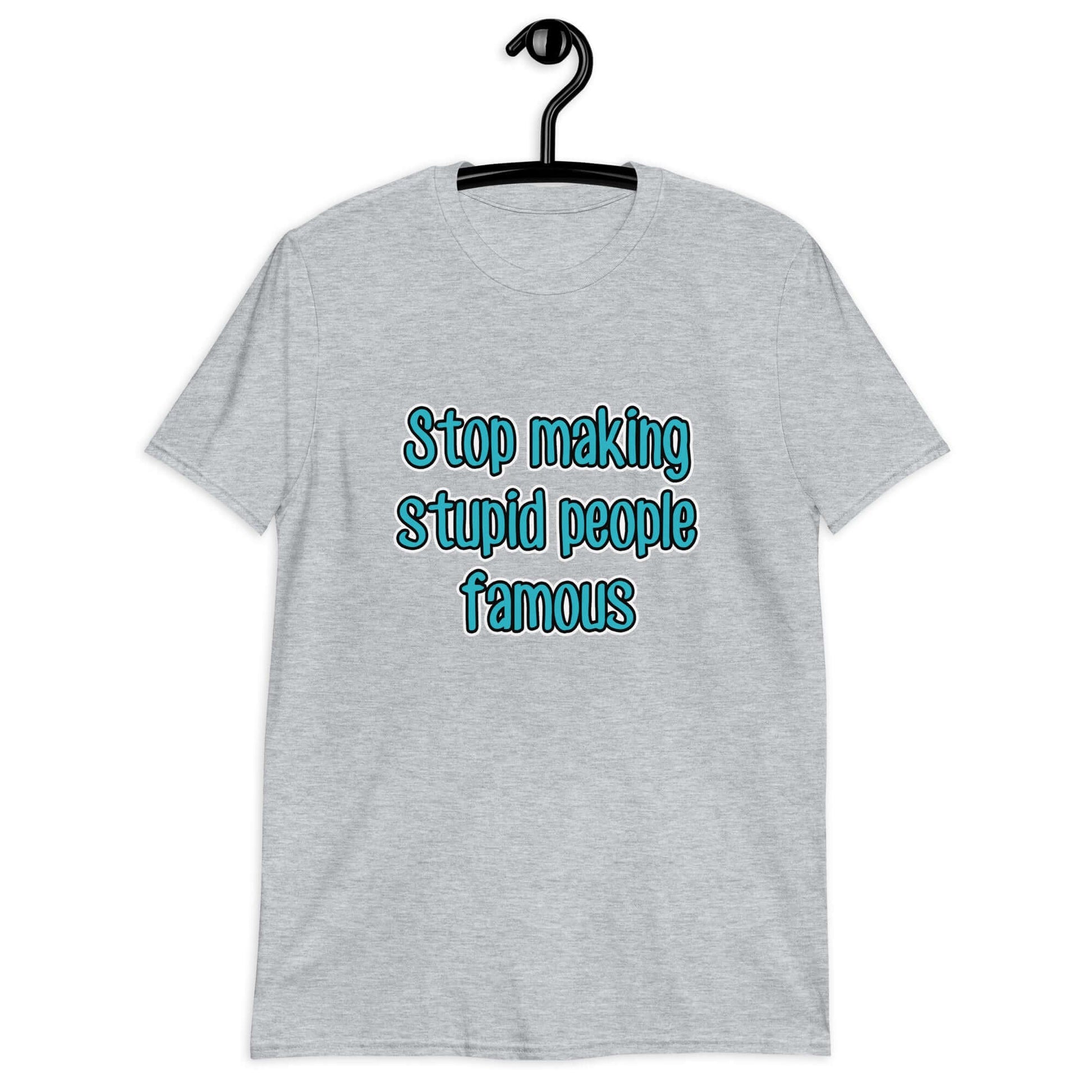 Light grey t-shirt with the phrase Stop making stupid people famous printed on the front. The text is turquoise. 