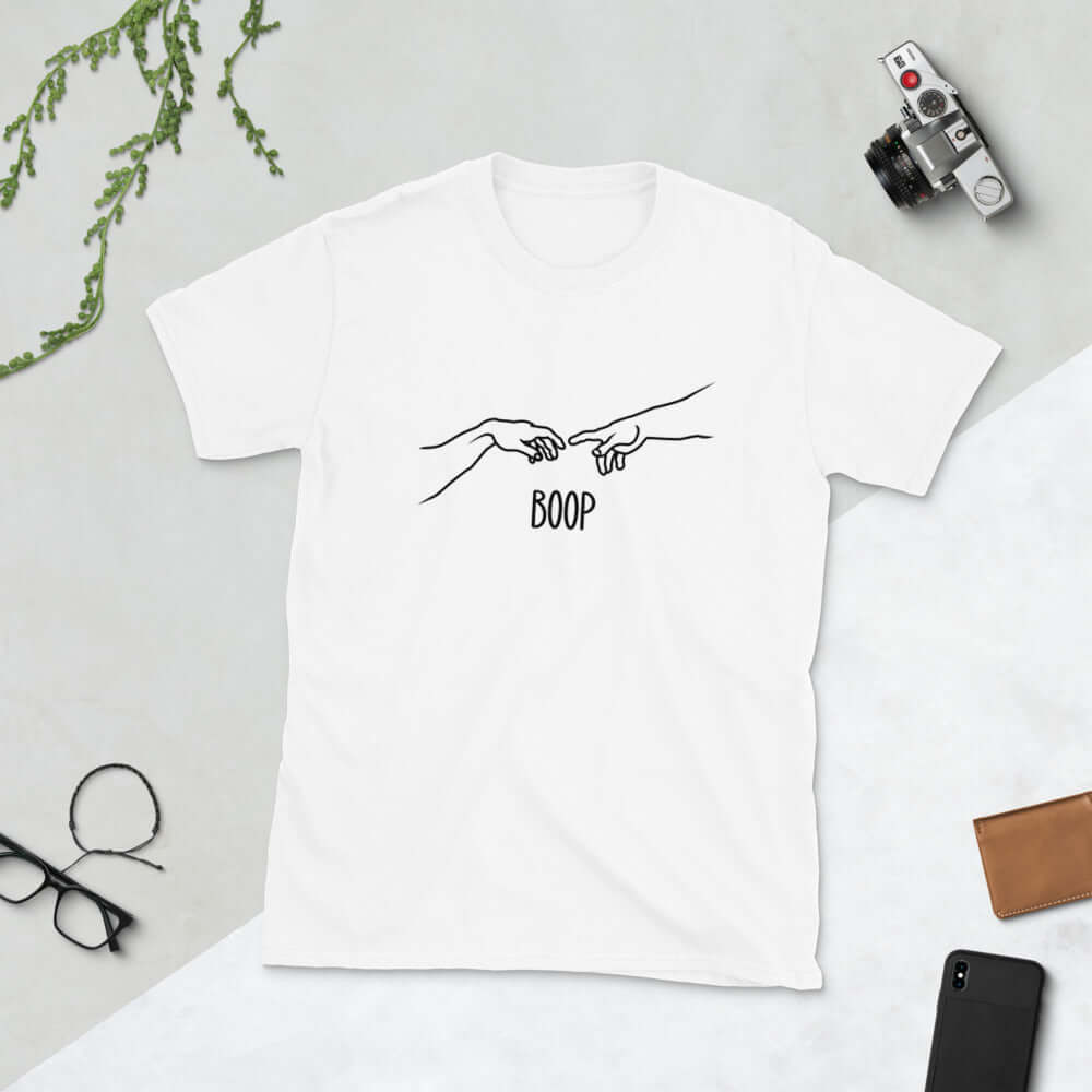 White t-shirt with line drawing hands reaching out and touching in the center like they in the famous art creation of Adam. The word Boop is printed underneath.