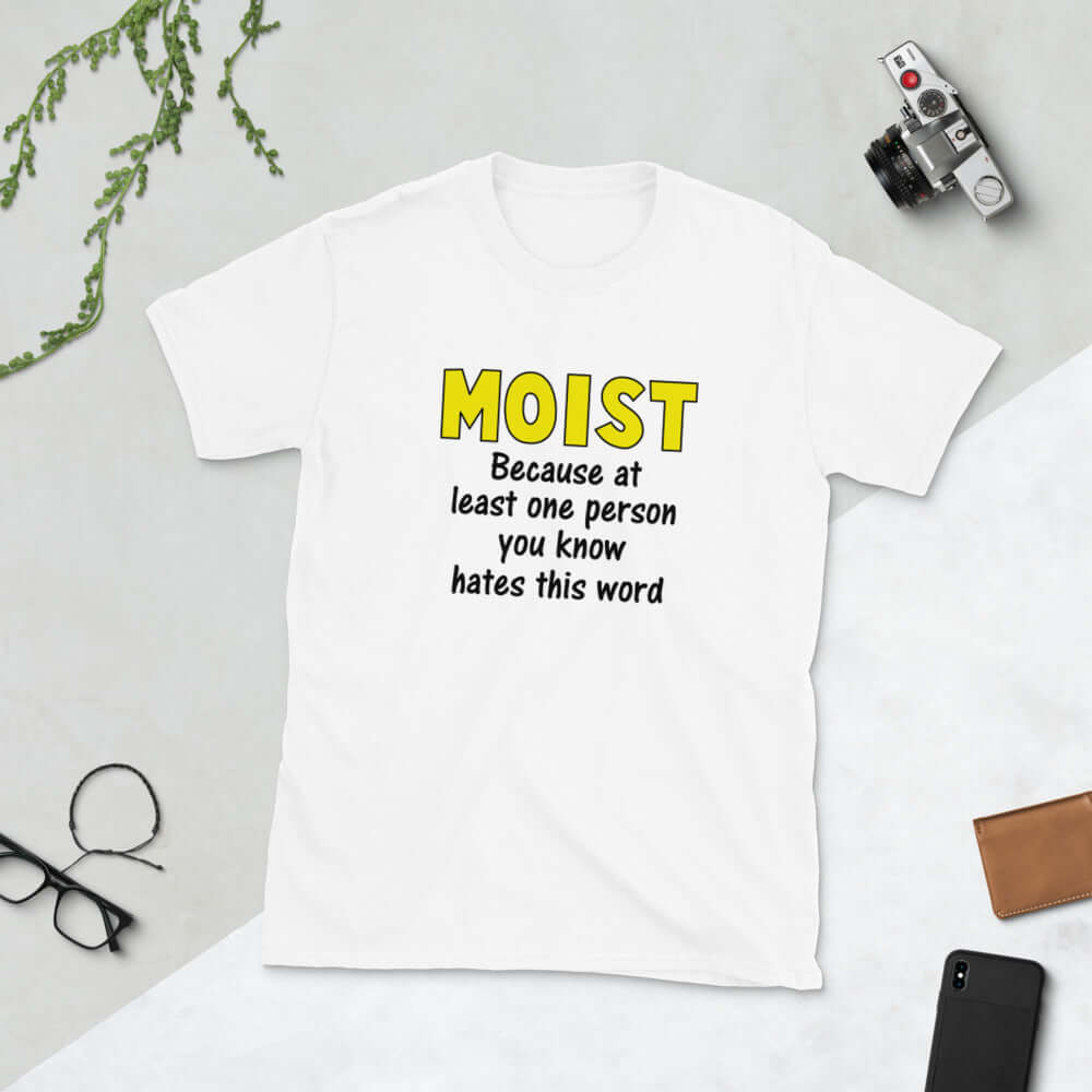 White t-shirt with the word Moist printed in large yellow bold font. In smaller font under the word moist is the phrase Because at least one person you know hates this word. 