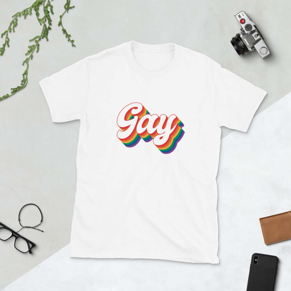 White t-shirt with the word Gay printed on the front. The word gay is outlined in rainbow.