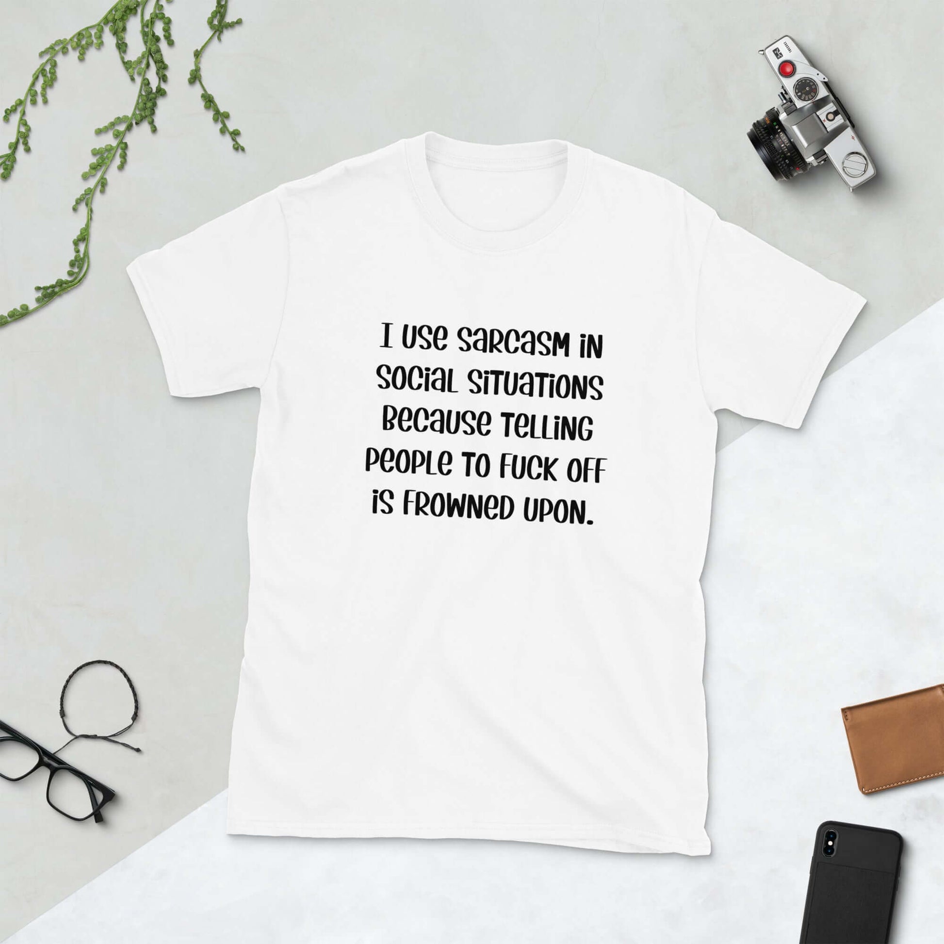 White t-shirt with the phrase I use sarcasm in social situations because telling people to fuck off is frowned upon printed on the front.
