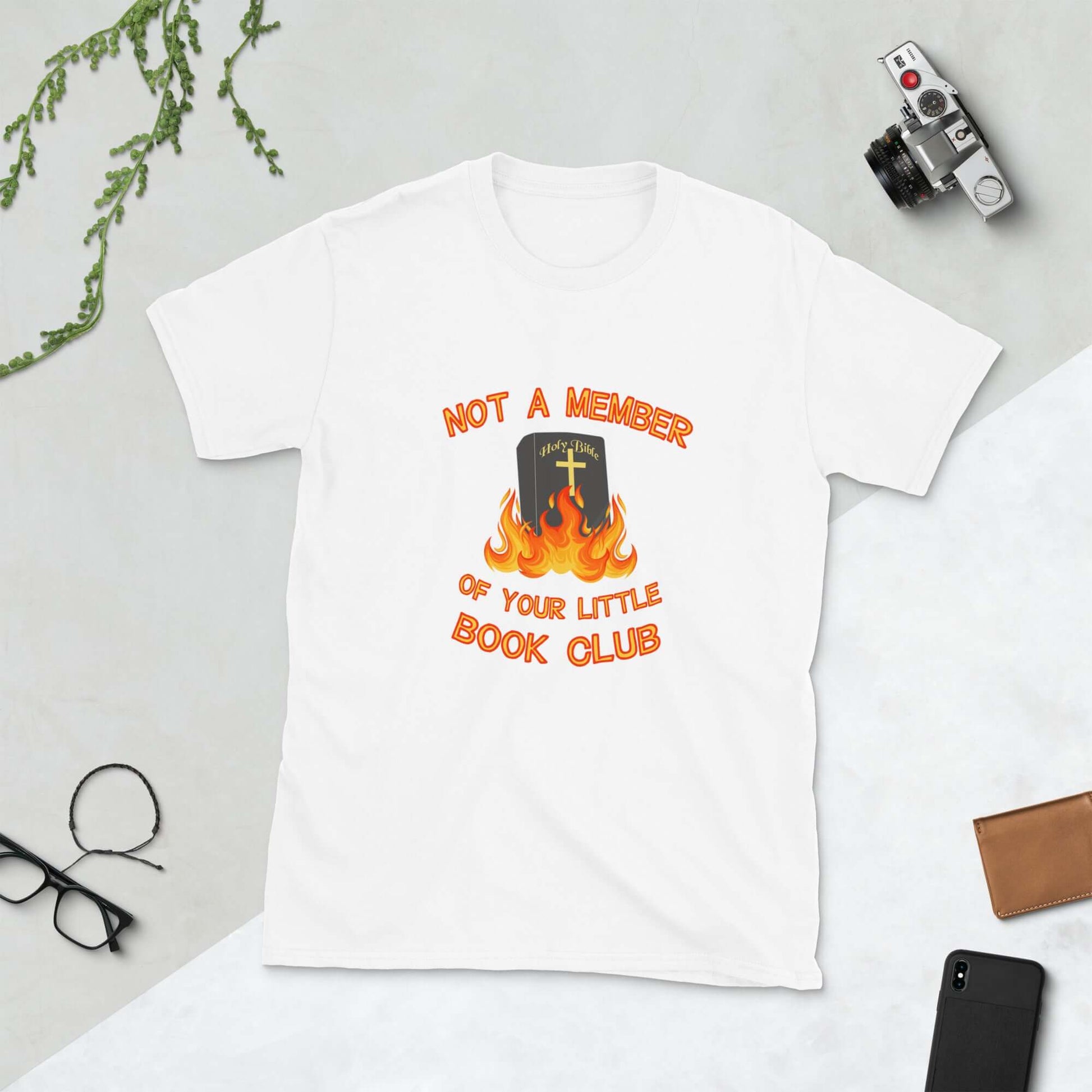 White t-shirt with image of a burning bible and the words Not a member of your little book club printed on the front.