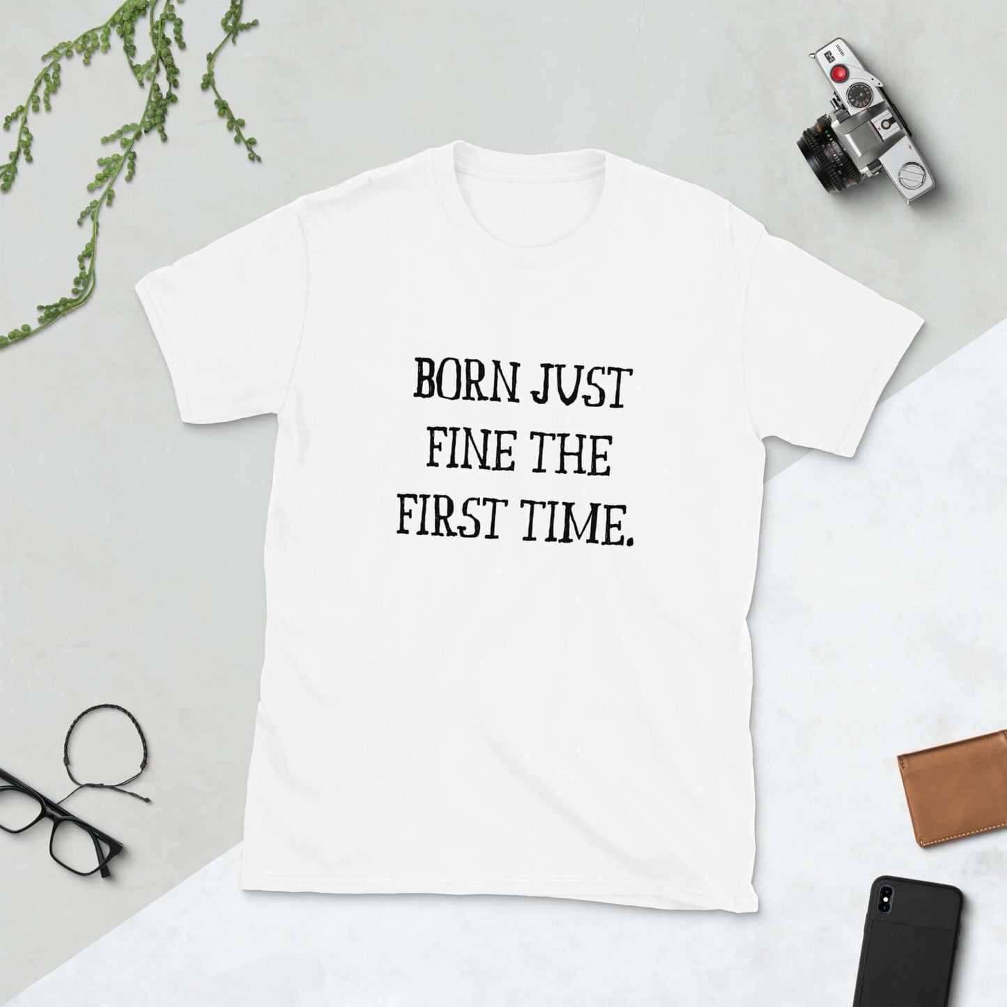 White t-shirt with the words Born just fine the first time printed on the front.