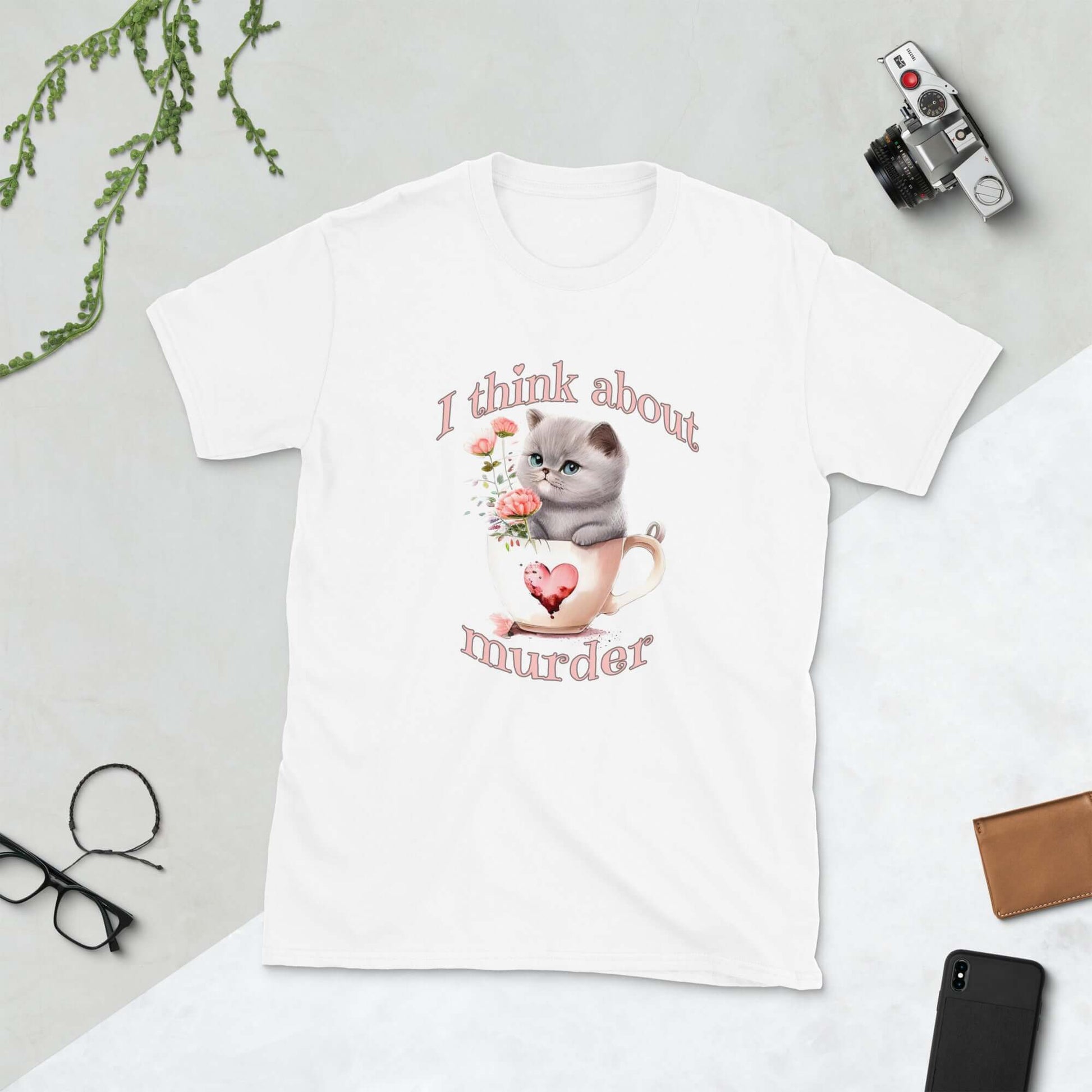 White t-shirt that says I think about murder with image of cute fluffy kitten sitting in a teacup printed on the front.