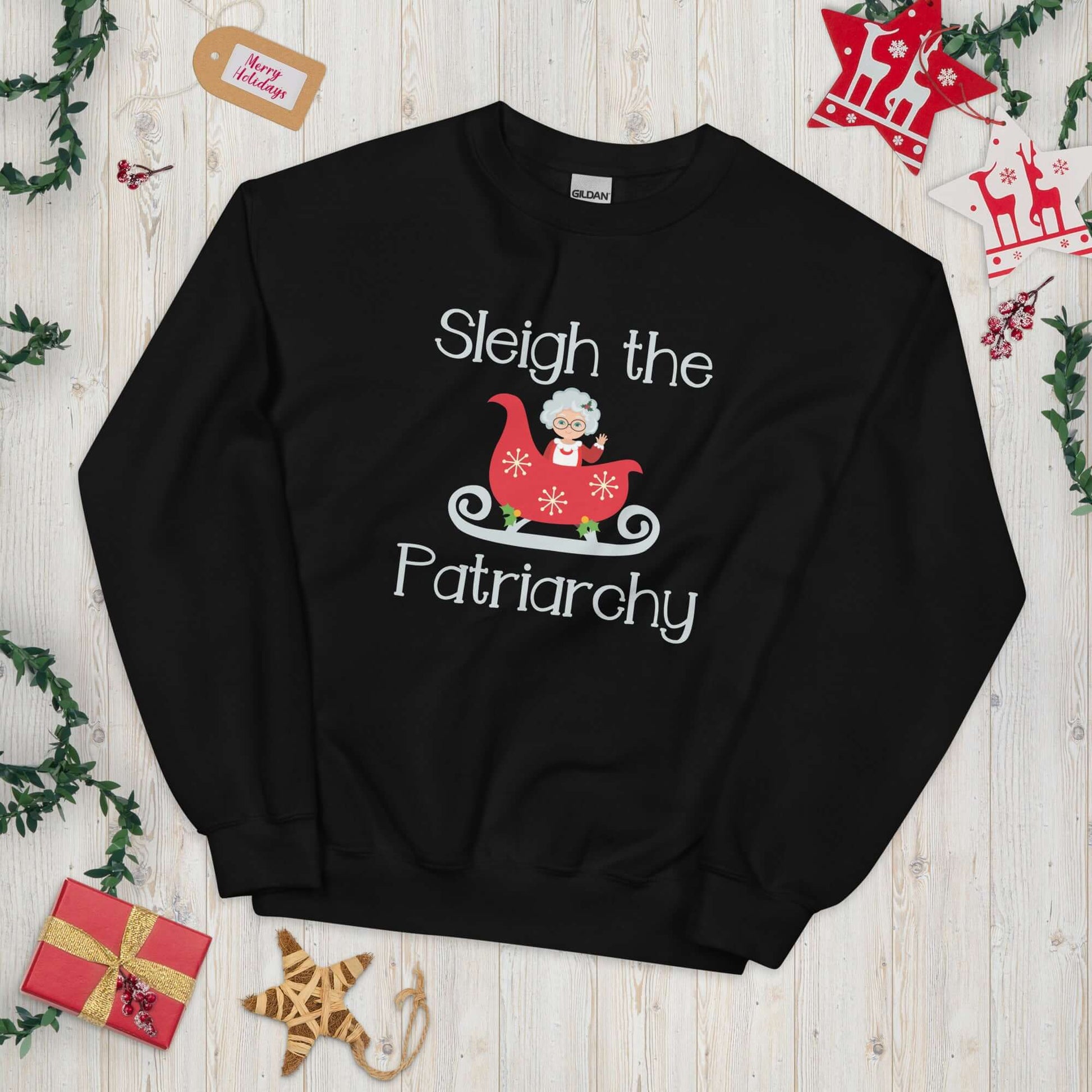 Black crewneck sweatshirt with graphic of Mrs. Claus sitting in a sleigh and the words Sleigh the patriarchy printed on the front.