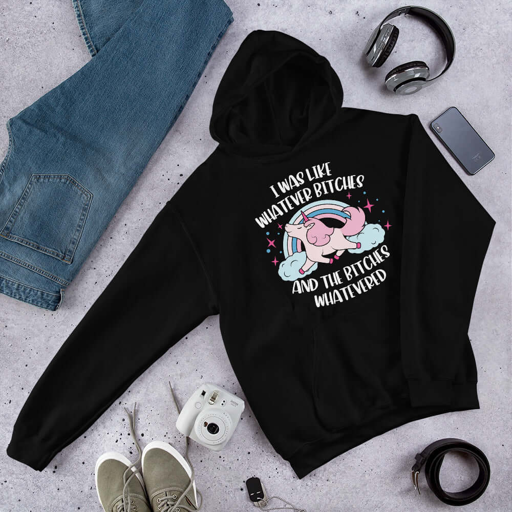 Black hoodie sweatshirt with a prancing unicorn rainbow graphic. The phrase I was like whatever bitches and the bitches whatevered printed on the front.