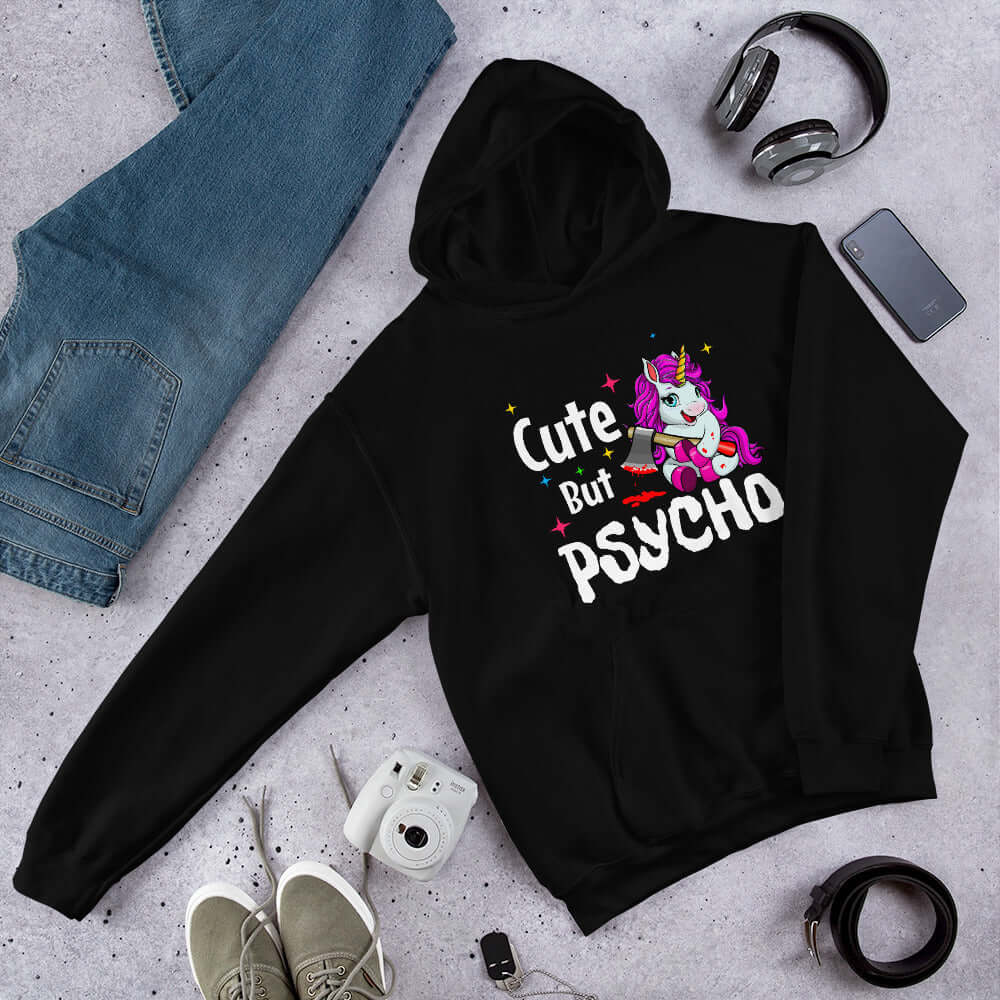 Black hoodie sweatshirt with a graphic of a unicorn holding a knife & the words Cute but psycho printed on the front.