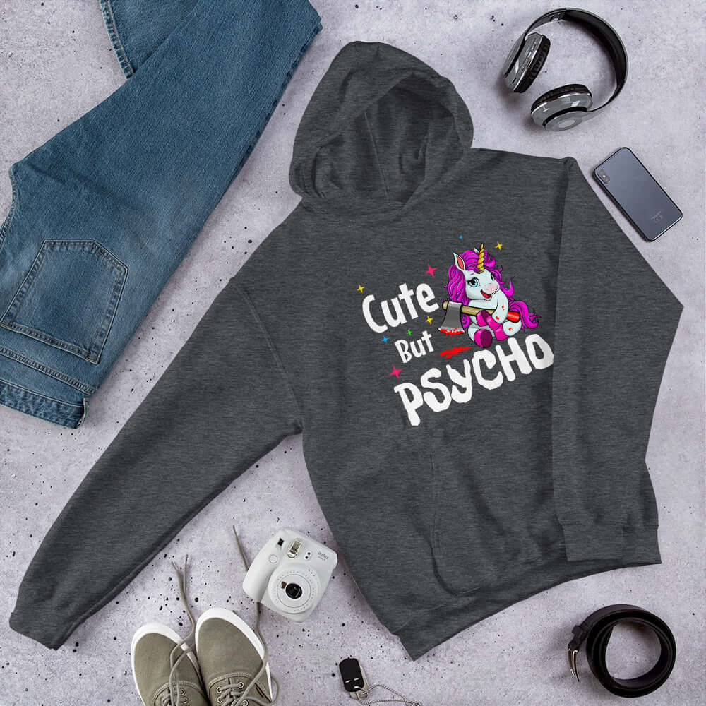 Dark heather grey hoodie sweatshirt with a graphic of a unicorn holding a knife & the words Cute but psycho printed on the front.