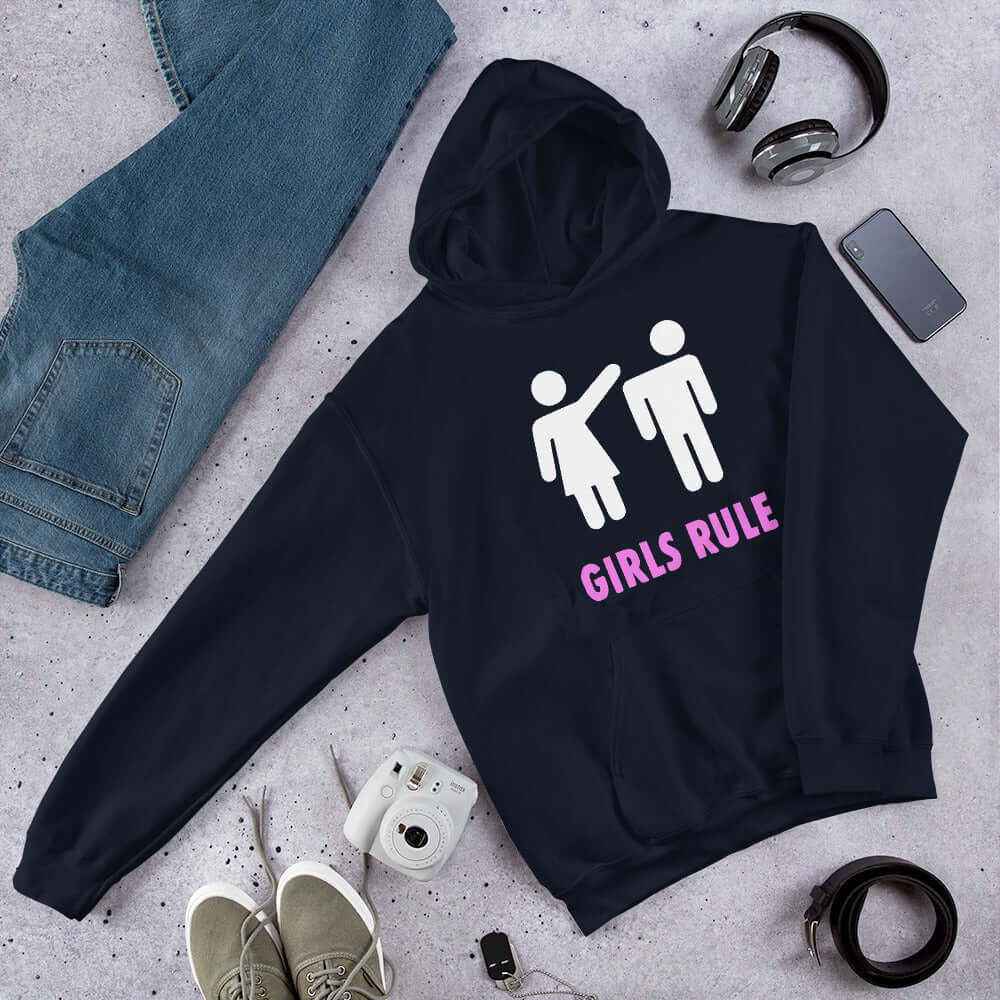 Navy blue hoodie sweatshirt. The sweatshirt has an image of a stick figure man and woman. The woman is punching the mans head off and the words Girls rule is printed beneath in hot pink. The graphics are printed on the front of the hoodie.