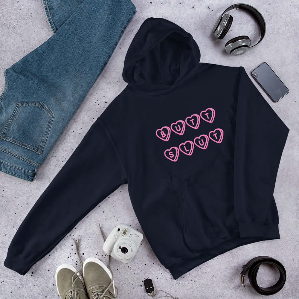 Navy blue hoodie sweatshirt with the words Butt Slut printed in pink on the front. Pink hearts are around each letter in the text.