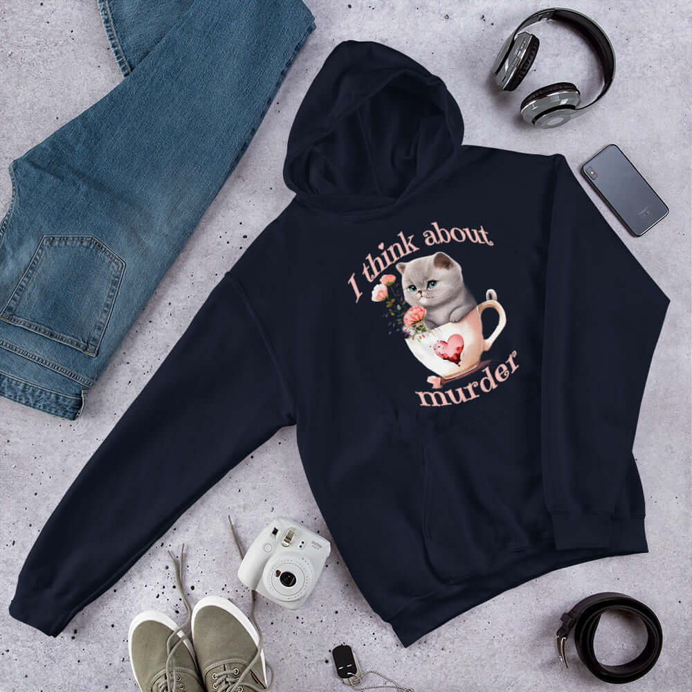 Navy blue hooded sweatshirt that says I think about murder with image of cute fluffy kitten sitting in a teacup printed on the front.