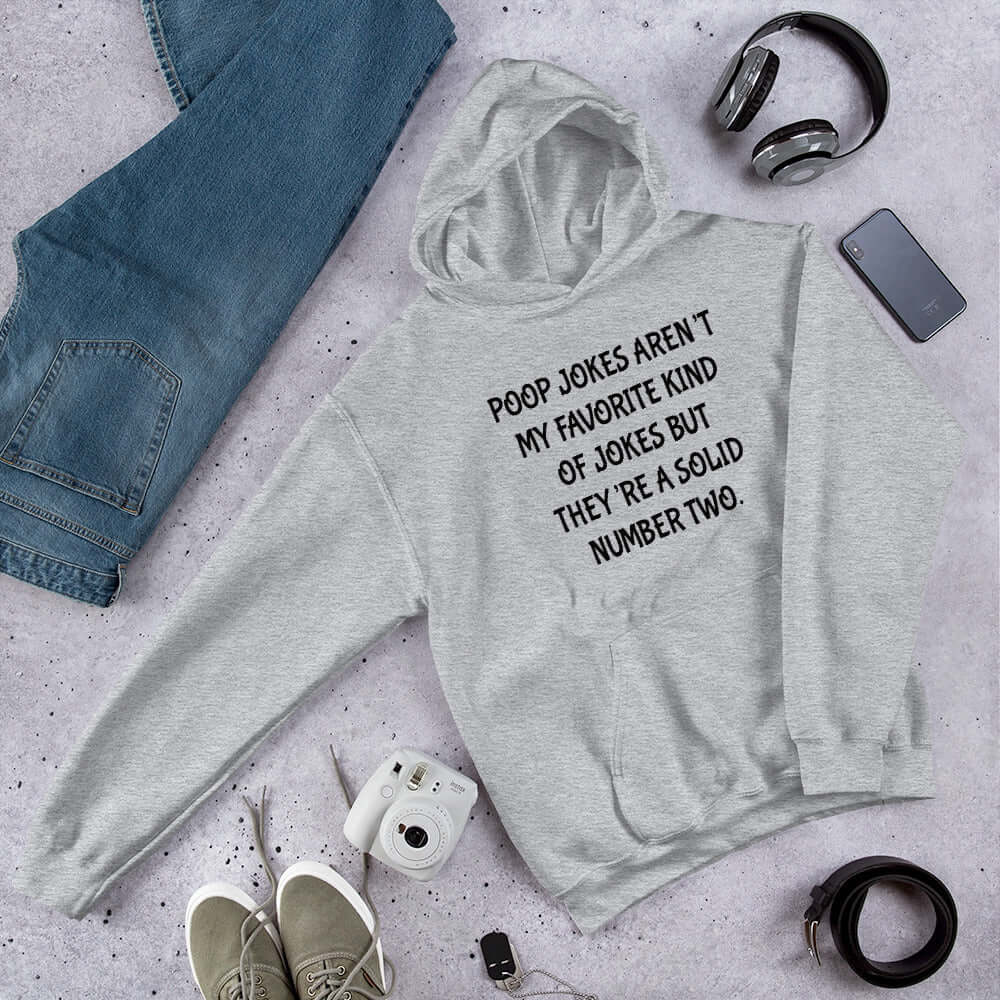 Light grey hoodie sweatshirt with the crude phrase Poop jokes aren't my favorite kind of jokes but they're a solid number 2 printed on the front.