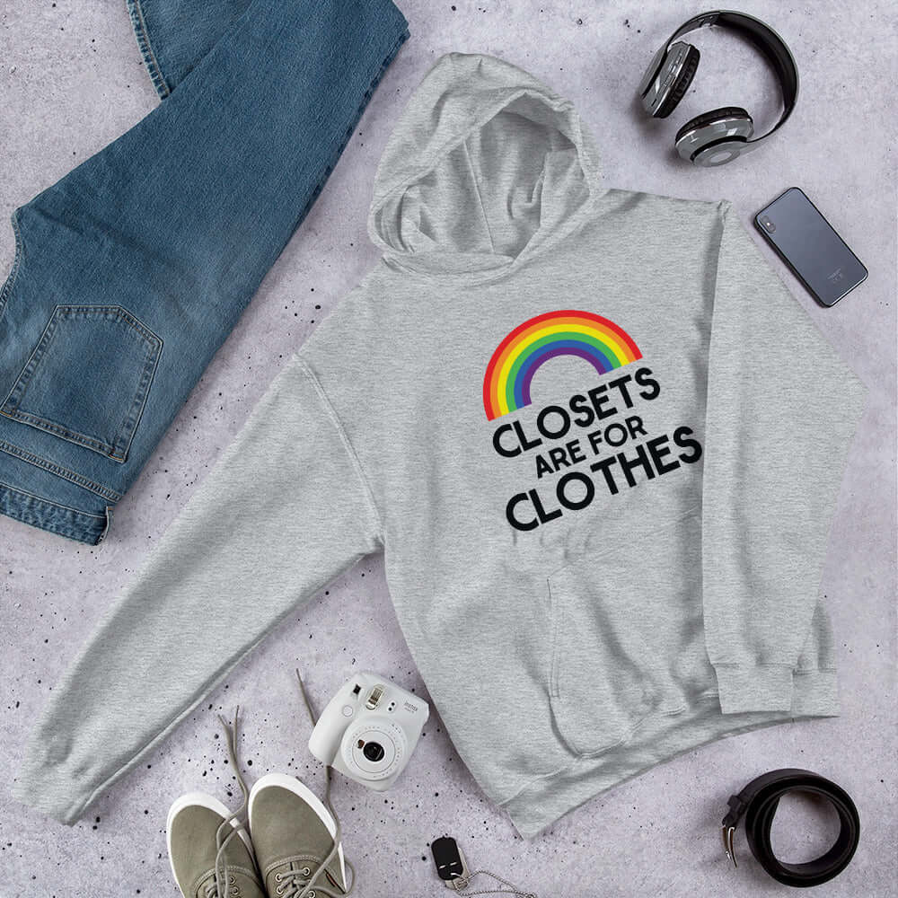 Light grey hoodie sweatshirt with a rainbow and the words Clothes are for closets printed on the front.